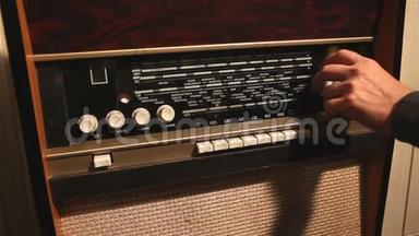 复古收音机，男人在旧收音机接收器上改变频率，旧接收器上改变频率